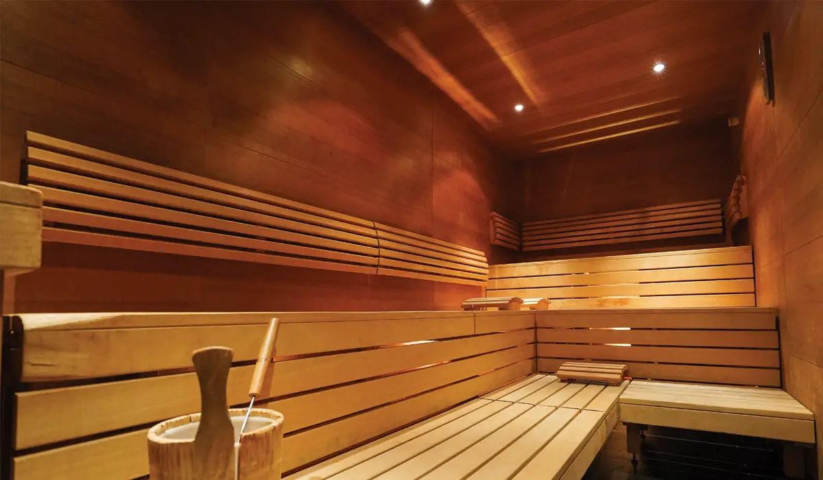 Sauna with long benches and a bucket