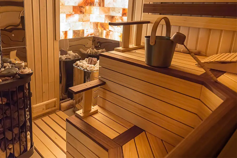 Sauna with multiple colors of Wood and a stove with hot rocks