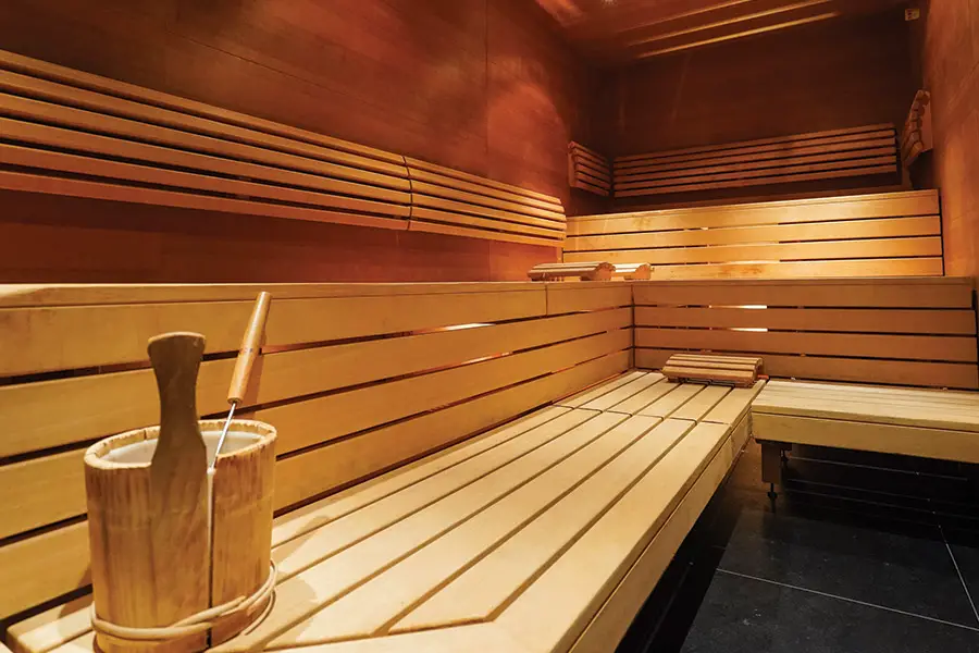 Sauna with long benches and a bucket