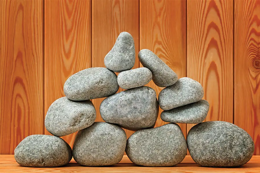 Sauna stones stacked on a wooden surface