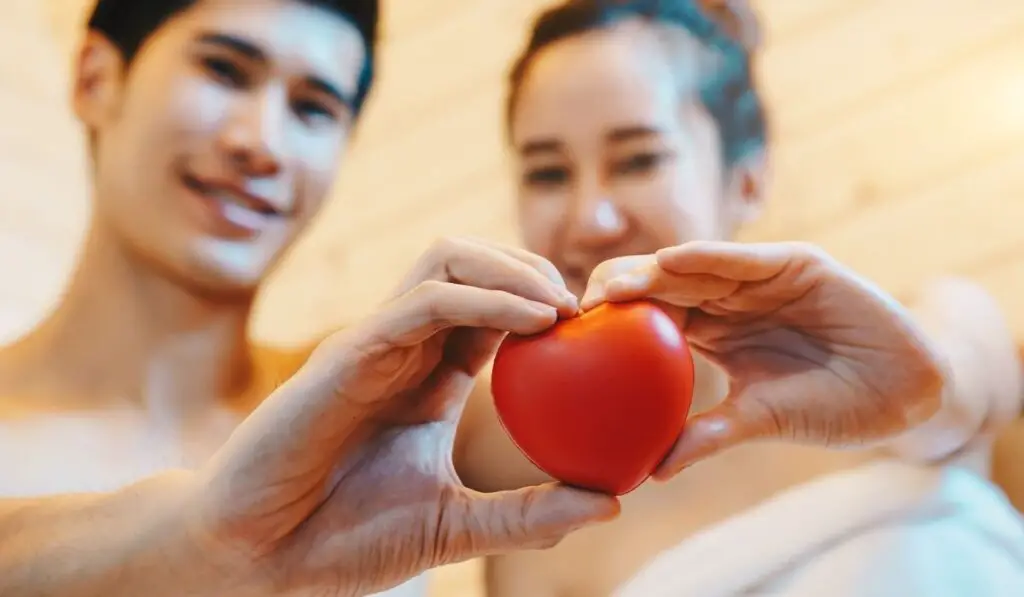Couple holding an apple in a sauna