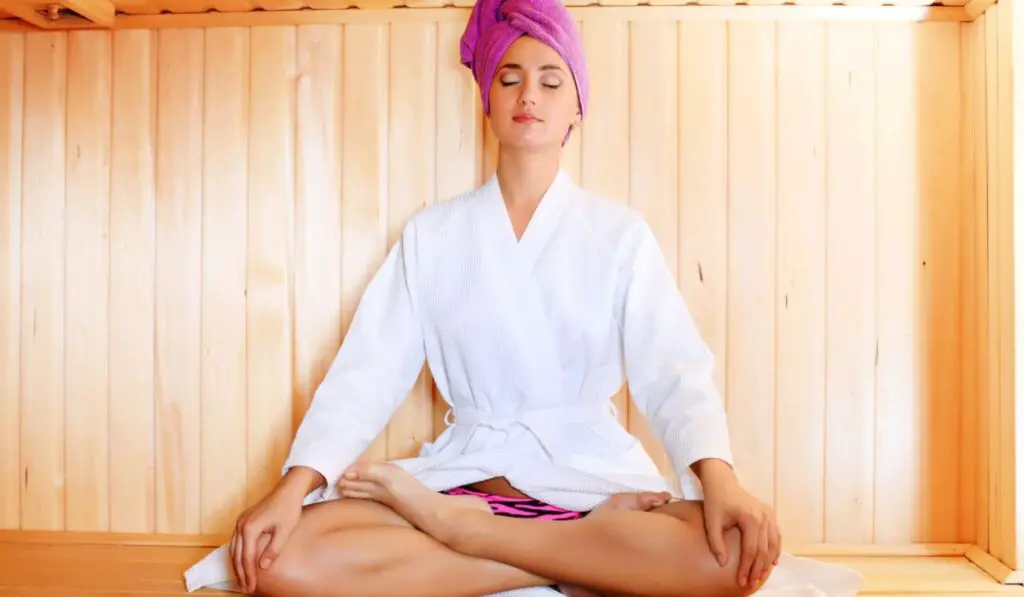 Woman sitting in a sauna meditating