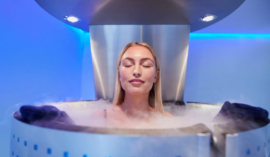 Young woman in a whole body cryotherapy cabin