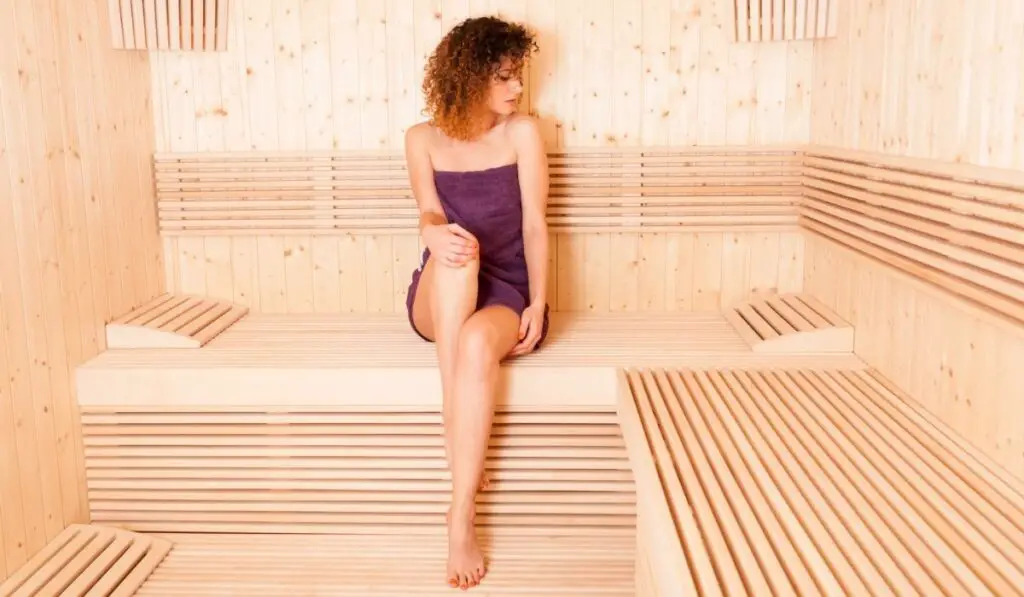 Woman with perfect skin taking body treatment in sauna
