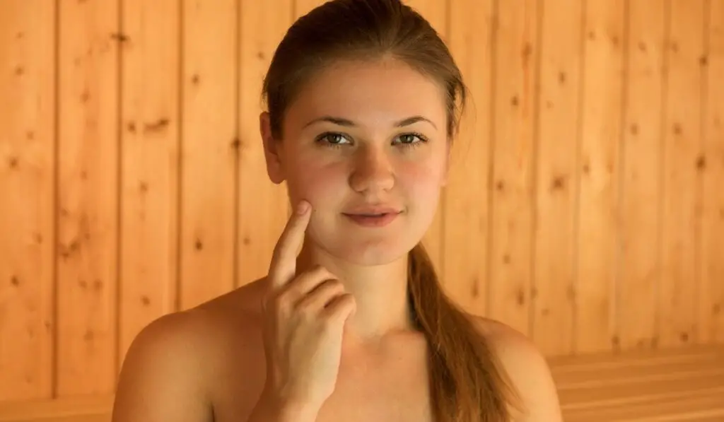 Young Woman Touching Her Face in a Sauna